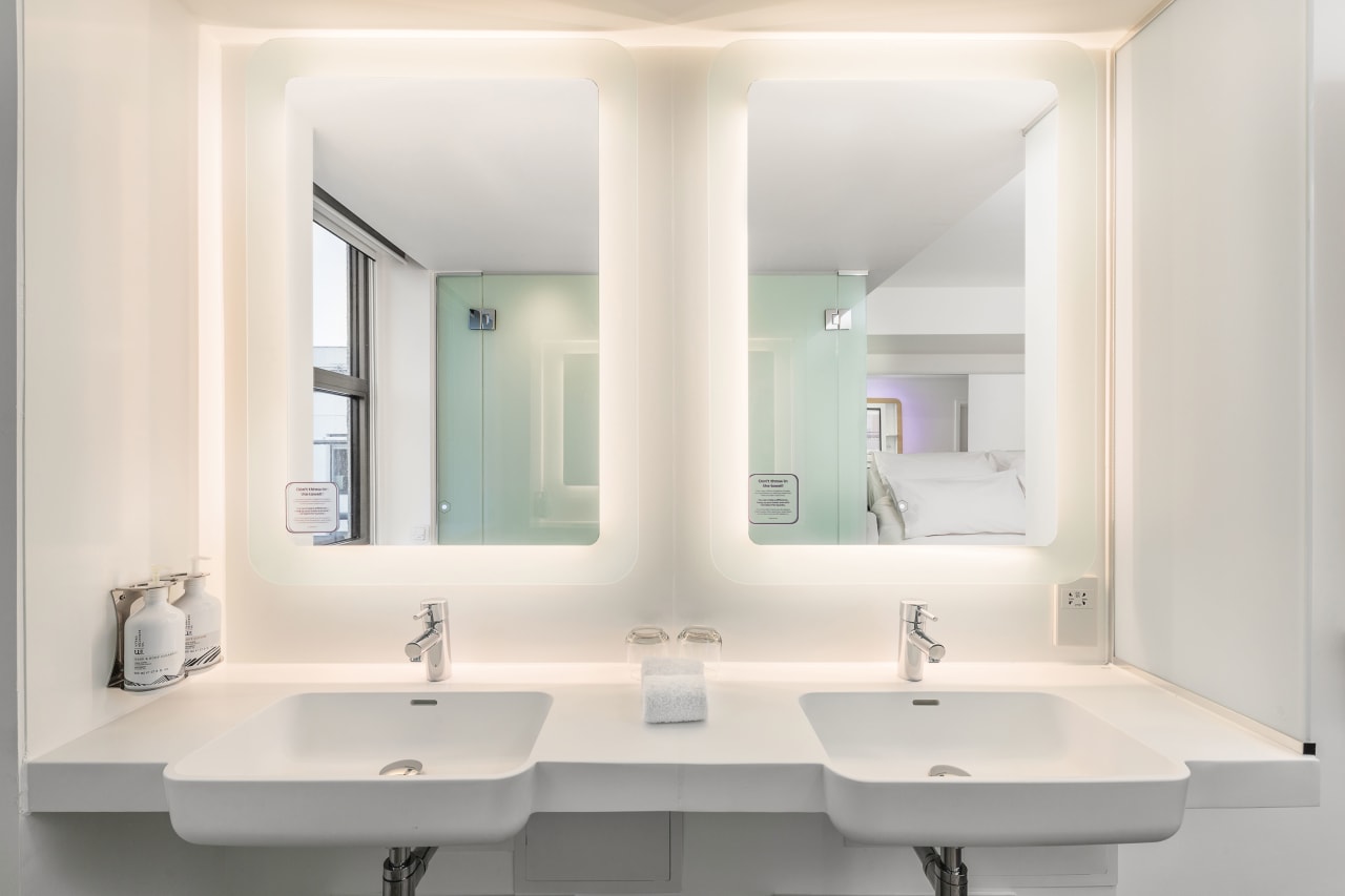 Working closely alongside YOTEL at the design stage of the project, Roca created a bathroom solution that closely aligned with the brand standards. This included the Gap wall‐hung WC and a bespoke vanity unit, in addition to bespoke washroom countertops for the public areas of the hotel. The bespoke units were made using Surfex®, a malleable solid surface material formulated from a combination of minerals and resins. The unique properties of Surfex allow it to be poured into a production mould, enabling complex designs with no joints or seams. The materials properties also permit ‘on-­‐site’ changes to the finished product, catering to different guestroom sizes and configurations. At YOTEL Edinburgh the advantages of Surfex were harnessed to create a wash basin bowl with an integrated unit that maximises countertop space, providing ample storage space for toiletries and grooming products.