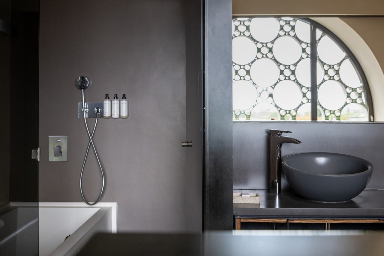 The design of this 13-room boutique hotel is inspired by the horizontal stacking of cava bottles and Antoni Gaudí’s trencadís technique. The sinuous lines, large circular windows and geometric patterns combined with the use of natural materials, create a balanced look in perfect harmony with the surroundings. The modern open-plan bathrooms feature graphite-coloured Bol basins, evocative Thesis basin mixers, and sculptural Happening toilets. The strong focus on sustainability, from the building’s thoughtful design approach to sustainable best practices, is also reflected in Roca’s products, which contribute to energy efficiency and durability.6