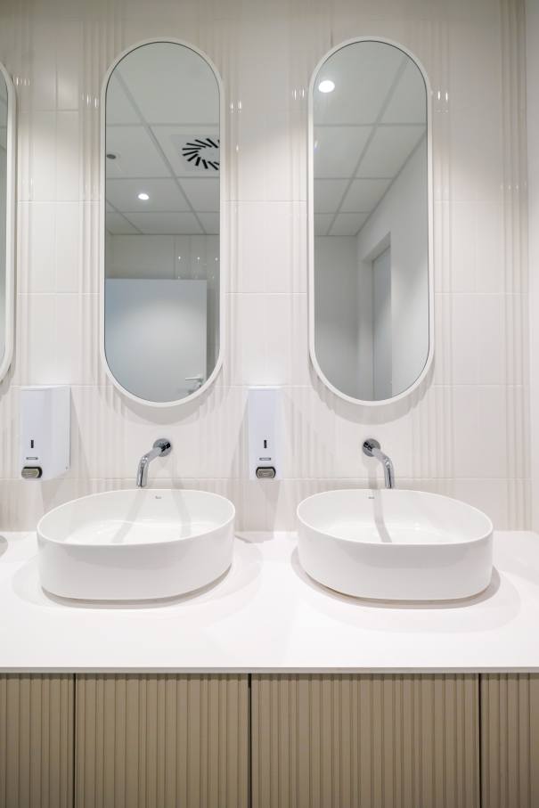 The interior design of TriQube's bathrooms embraces a serene, minimalist aesthetic, with rounded shapes and a soothing colour palette creating a calming atmosphere. Chic urinals add a touch of distinction, offering both urban flair and unique appeal, while Access grab bars and Meridian toilets ensure accessibility and comfort. Roca products were carefully selected to enhance both the functionality and innovative spirit of the space, contributing to its high standards of quality and design.9