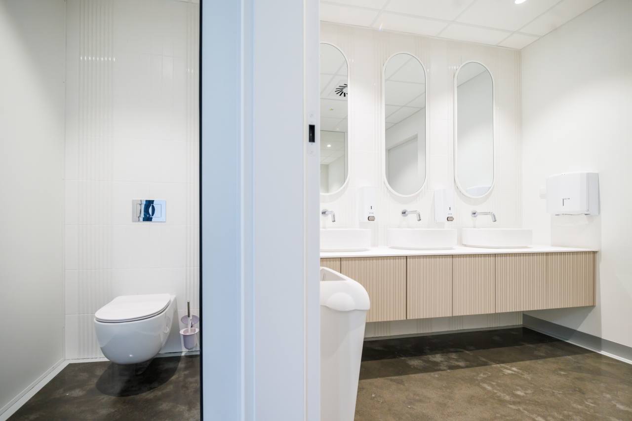 The interior design of TriQube's bathrooms embraces a serene, minimalist aesthetic, with rounded shapes and a soothing colour palette creating a calming atmosphere. Chic urinals add a touch of distinction, offering both urban flair and unique appeal, while Access grab bars and Meridian toilets ensure accessibility and comfort. Roca products were carefully selected to enhance both the functionality and innovative spirit of the space, contributing to its high standards of quality and design.2