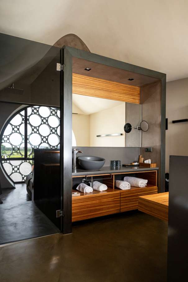The design of this 13-room boutique hotel is inspired by the horizontal stacking of cava bottles and Antoni Gaudí’s trencadís technique. The sinuous lines, large circular windows and geometric patterns combined with the use of natural materials, create a balanced look in perfect harmony with the surroundings. The modern open-plan bathrooms feature graphite-coloured Bol basins, evocative Thesis basin mixers, and sculptural Happening toilets. The strong focus on sustainability, from the building’s thoughtful design approach to sustainable best practices, is also reflected in Roca’s products, which contribute to energy efficiency and durability.