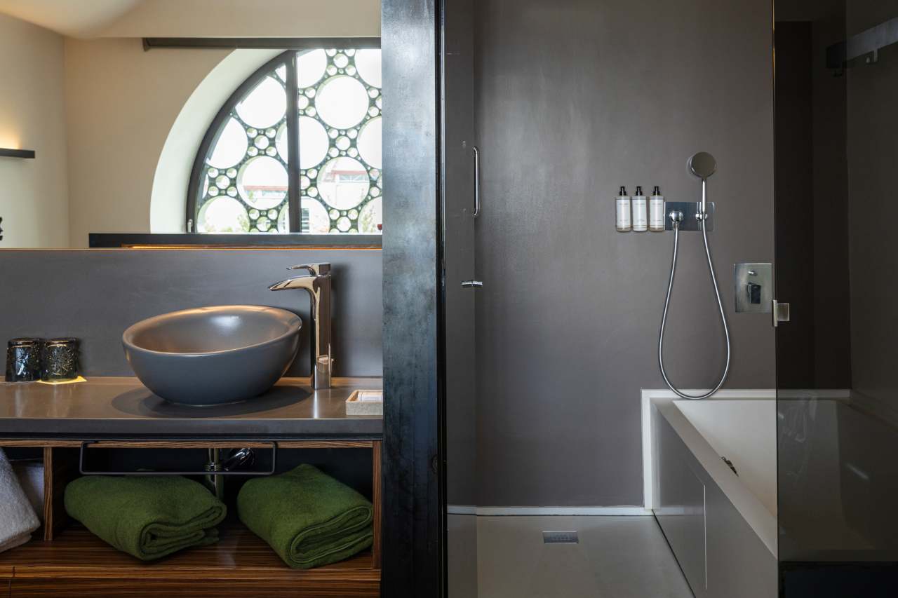 The design of this 13-room boutique hotel is inspired by the horizontal stacking of cava bottles and Antoni Gaudí’s trencadís technique. The sinuous lines, large circular windows and geometric patterns combined with the use of natural materials, create a balanced look in perfect harmony with the surroundings. The modern open-plan bathrooms feature graphite-coloured Bol basins, evocative Thesis basin mixers, and sculptural Happening toilets. The strong focus on sustainability, from the building’s thoughtful design approach to sustainable best practices, is also reflected in Roca’s products, which contribute to energy efficiency and durability.4