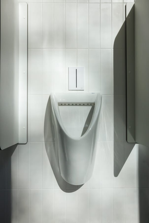 The interior design of TriQube's bathrooms embraces a serene, minimalist aesthetic, with rounded shapes and a soothing colour palette creating a calming atmosphere. Chic urinals add a touch of distinction, offering both urban flair and unique appeal, while Access grab bars and Meridian toilets ensure accessibility and comfort. Roca products were carefully selected to enhance both the functionality and innovative spirit of the space, contributing to its high standards of quality and design.8