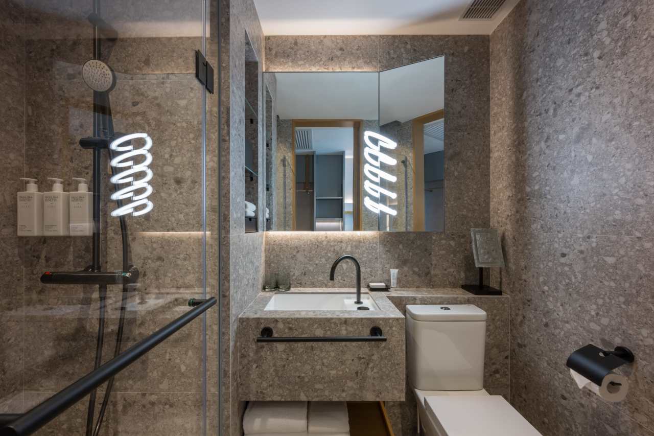 The Mondrian Hong Kong and Roca share a commitment to boundary-pushing creativity, evident in the hotel's theatrical interiors and innovative design. Roca's solutions, including The Gap WCs, Genova baths and Victoria-T thermostatic shower columns, combine functionality with sleek aesthetics. The overall guest experience is enhanced by such features as slow-closing seats and precise temperature control. The Toga basin faucet in brushed titanium black complements the bathroom's dark grey marble to create a sophisticated and dynamic atmosphere.1