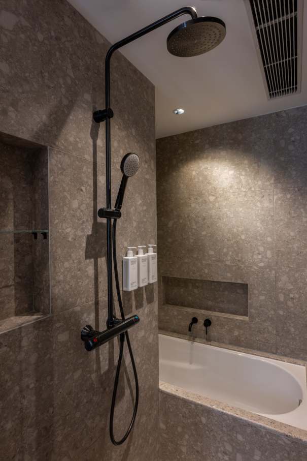 The Mondrian Hong Kong and Roca share a commitment to boundary-pushing creativity, evident in the hotel's theatrical interiors and innovative design. Roca's solutions, including The Gap WCs, Genova baths and Victoria-T thermostatic shower columns, combine functionality with sleek aesthetics. The overall guest experience is enhanced by such features as slow-closing seats and precise temperature control. The Toga basin faucet in brushed titanium black complements the bathroom's dark grey marble to create a sophisticated and dynamic atmosphere.